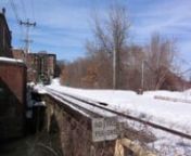 NECR 4285, the green monster being pushed by the 2 locomotives, is a vintage Jordan Spreader previously owned by Central Vermont (CV). Shown in this clip on snow plow duty, the colorful consist passes over the 150+ year old stone arch railroad bridge in Brattleboro, VT. NECR GP38 3847 &amp; GSWR SD9 1900 are providing the pushing power. The 1900 is rarely seen here, as it is usually run between St. Albans, VT and White River Jct., VT. nI recorded this video myself (actually using a tripod for th