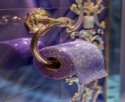 Prompt Midjourney : Glamorous luxury toilet paper holder with swarovski crystals in a lilac color, hanging on the wall of an expensive bathroom, with golden and crystal details, closeup photo for a magazine cover shot in the style of Hengki Koentjoro.The light shining on the subject is quite dreamy and luxurious --v 6.0 --ar 3:4